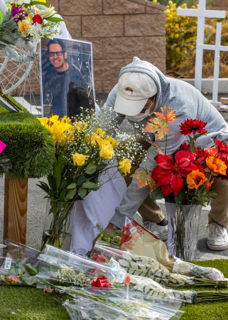 Dan Toledo places some flowers for his friend Gerard Nieva at a growing memorial during a vigil ...