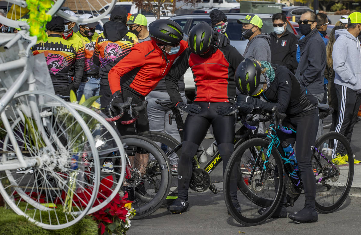 Cyclists comfort each other during a vigil honoring the lives of five Las Vegas cyclists who lo ...