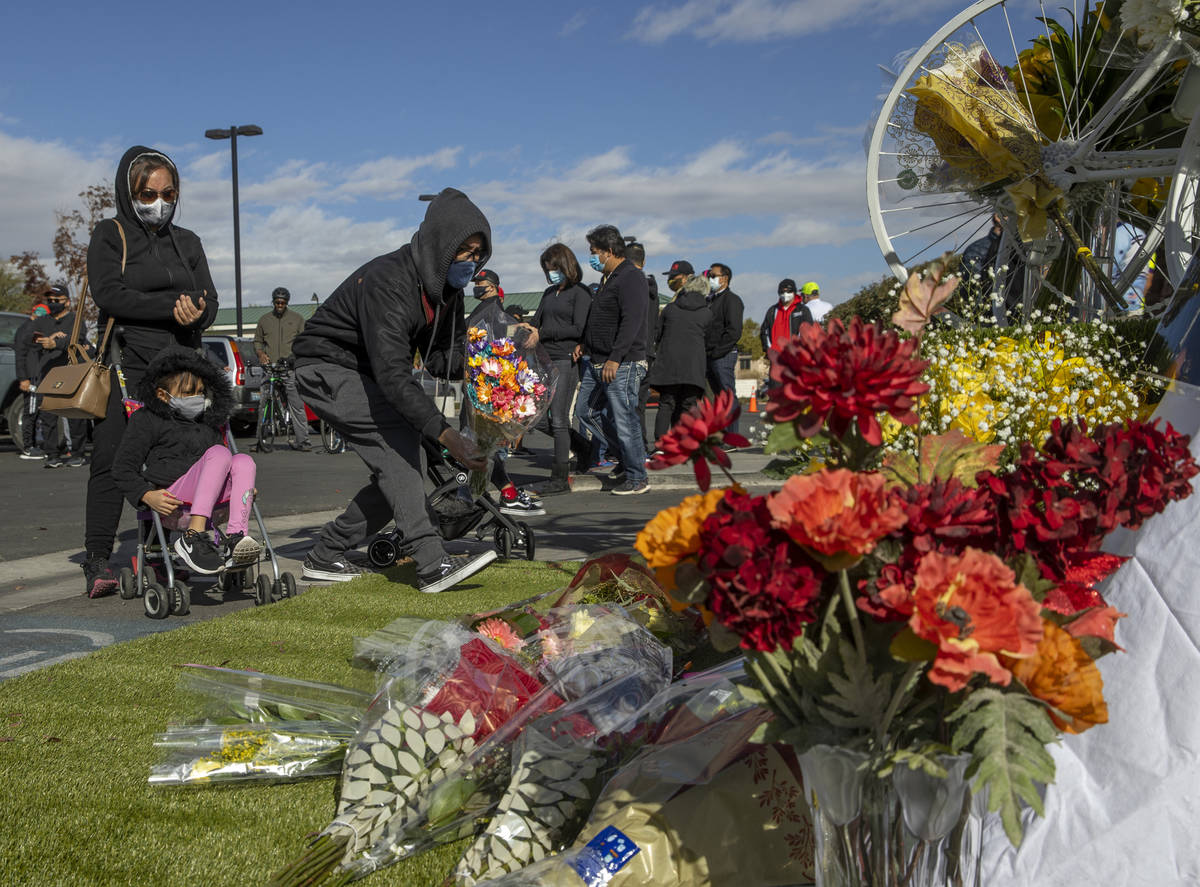 Mourners leave more flowers at a growing memorial during a vigil honoring the lives of five Las ...