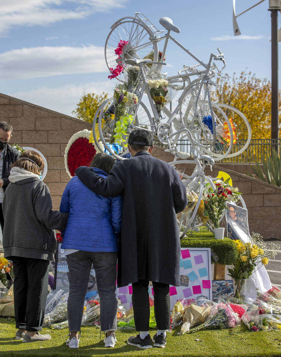Attendees look to a growing memorial during a vigil honoring the lives of five Las Vegas cyclis ...