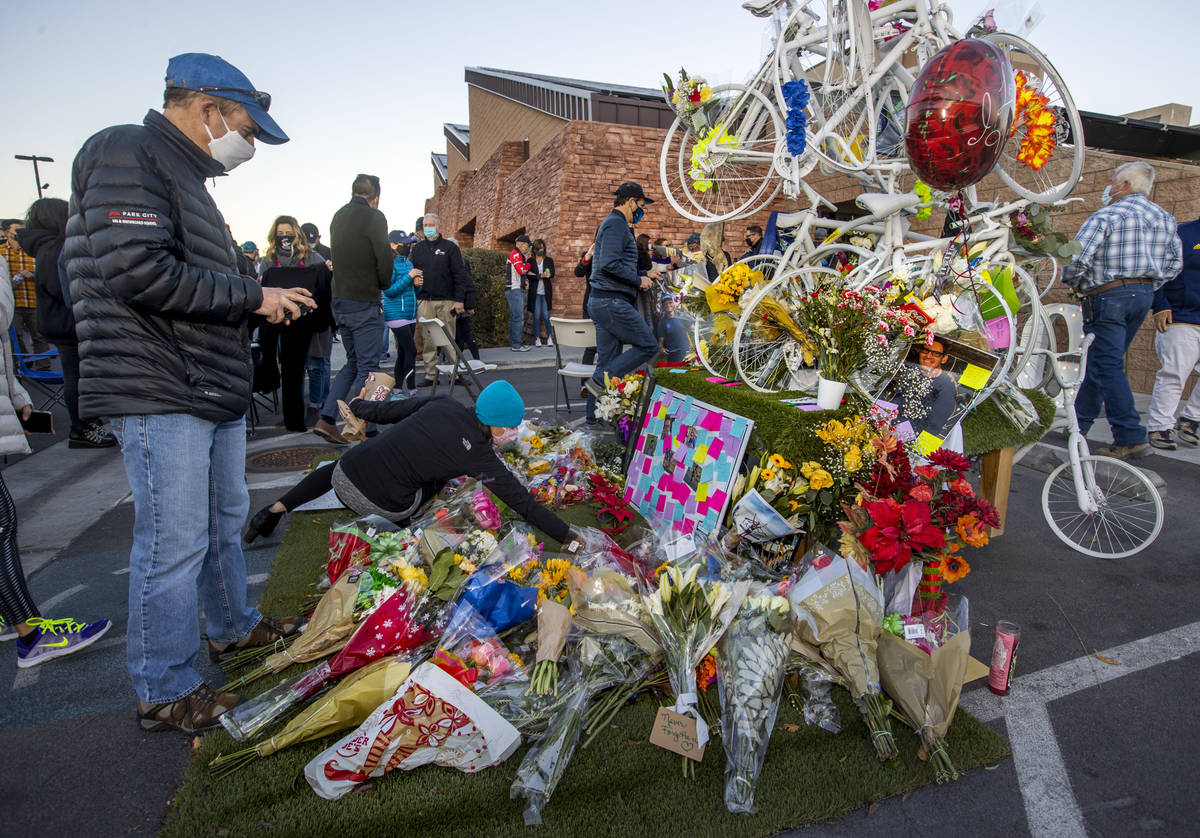 More flowers are added to a memorial during a vigil honoring the lives of five Las Vegas cyclis ...