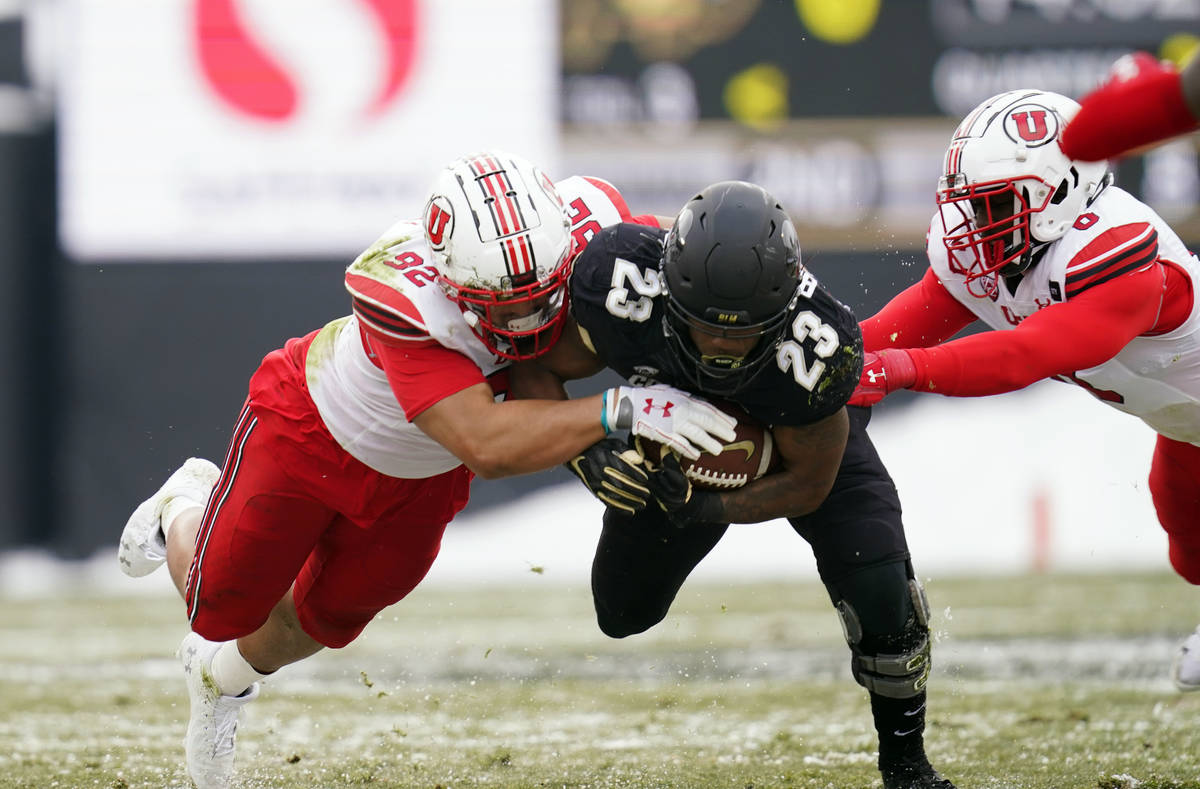 Colorado running back Jarek Broussard, center, is stopped after a short gain by Utah defensive ...