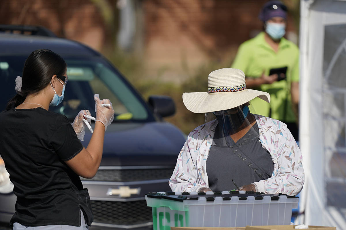 Healthcare workers ready COVID-19 tests for examination at a drive-thru testing center Tuesday, ...