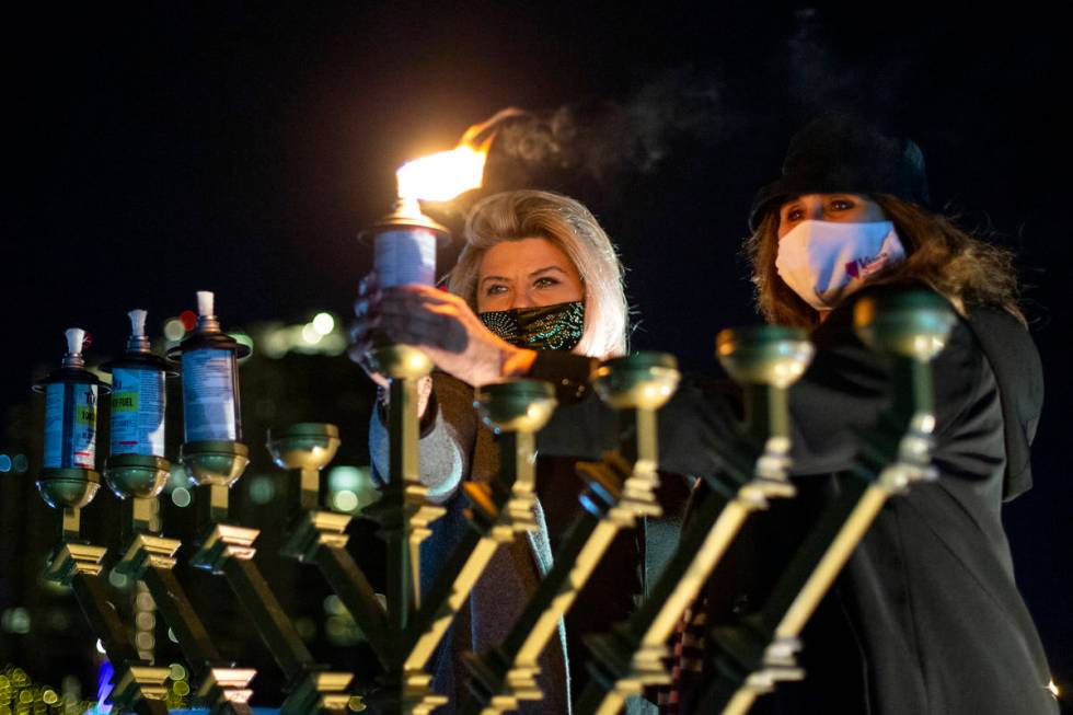 Las Vegas Councilwomen Michele Fiore and Victoria Seaman light the menorah during a drive-in Ha ...