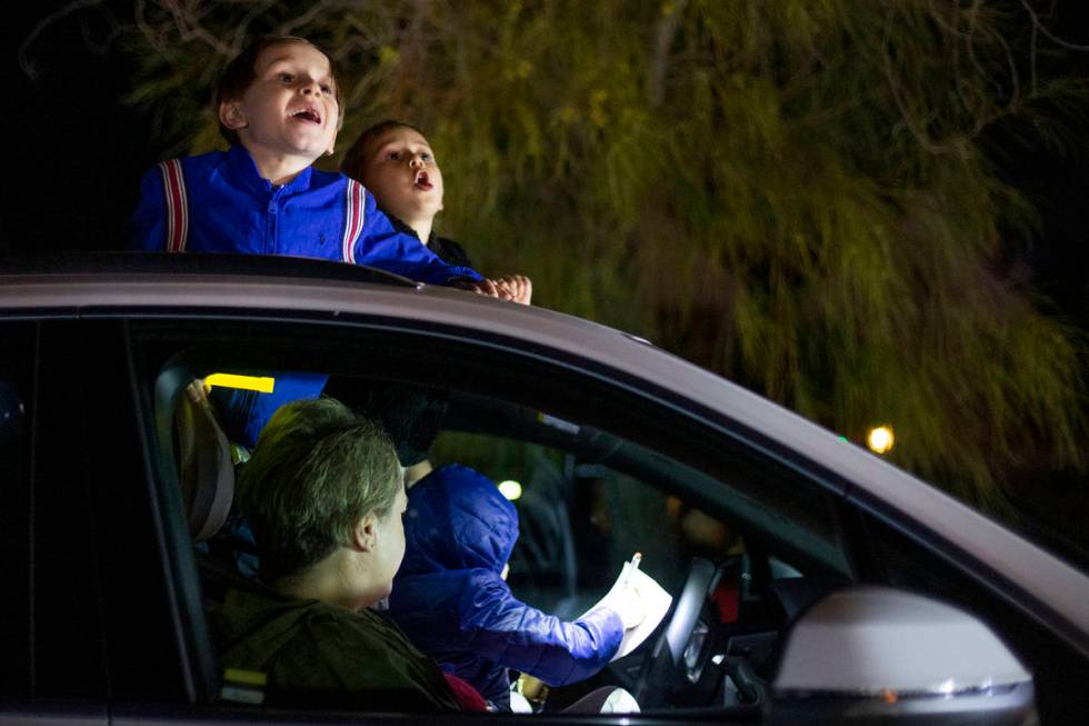Ben Amor, 6, left, and Sophie Nisgoda, 4, right, shout out their bingo cards during a drive-in ...