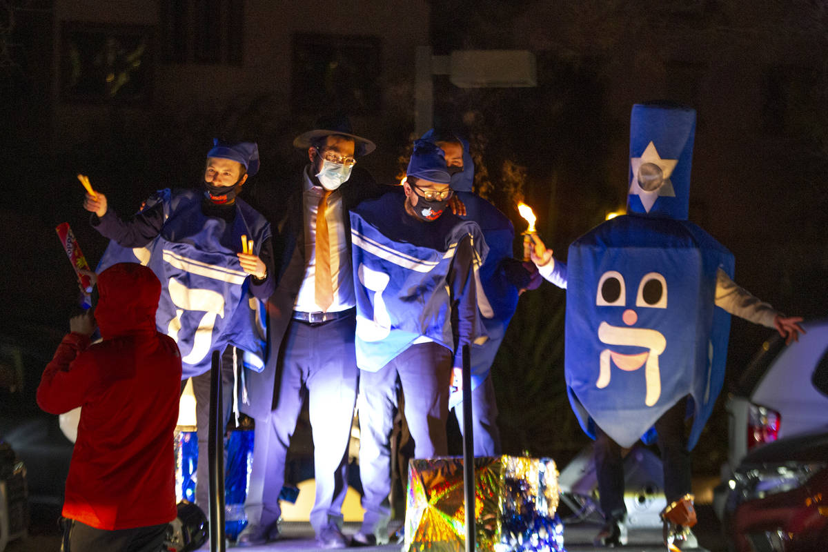People dressed as dreidels dance during a drive-in Hanukkah event at the Israeli American Counc ...