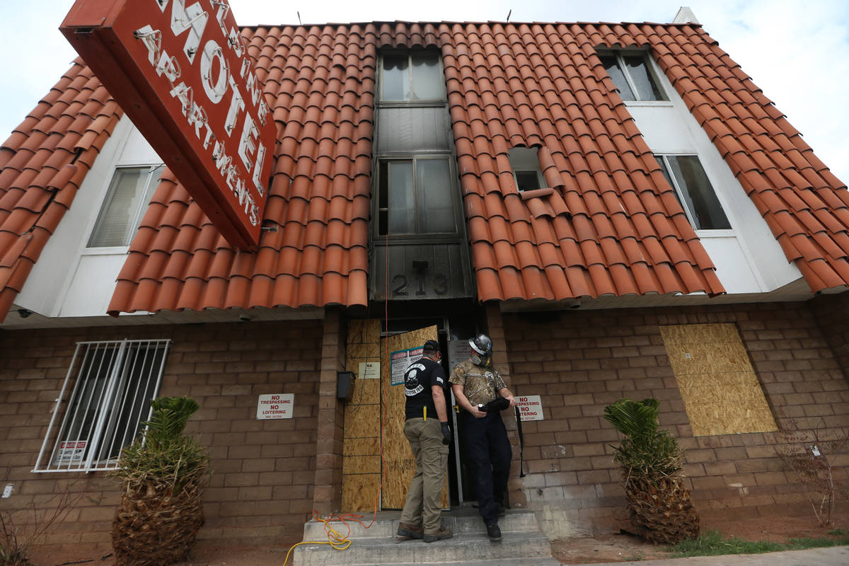 Employees with the Forensic Investigations Group work inside the Alpine Motel during an investi ...