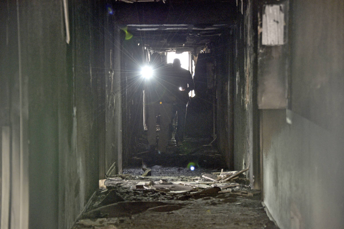 Investigators walk through an interior corridor Dec. 21, 2019 after an early-morning fire at th ...