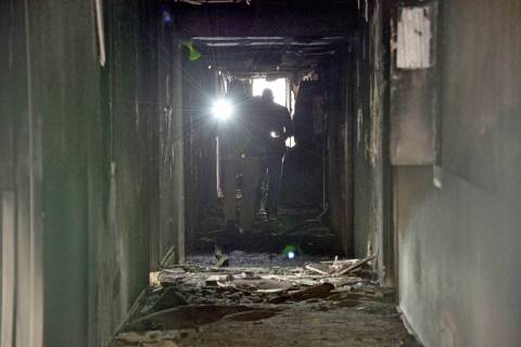 Investigators walk through an interior corridor Dec. 21, 2019 after an early-morning fire at th ...