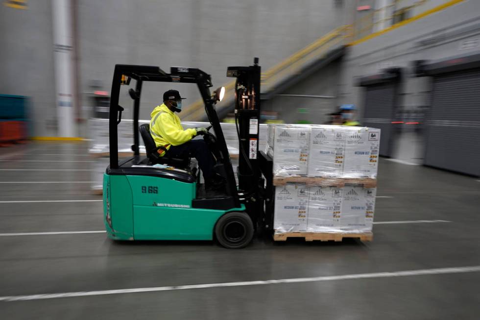 Boxes containing the Pfizer-BioNTech COVID-19 vaccine are brought to to the loading dock for sh ...