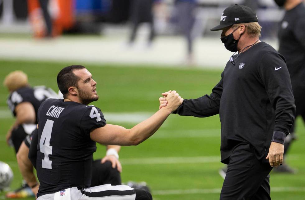 Raiders head coach Jon Gruden, right, greets Raiders quarterback Derek Carr (4) during warm ups ...