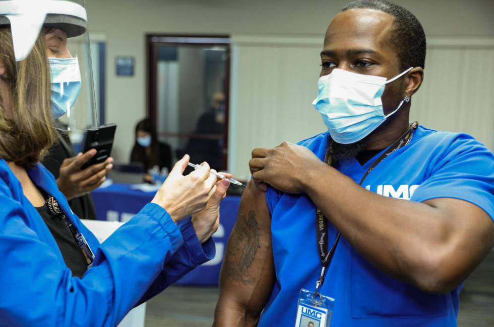 University Medical Center Employee Health Nurse Lori Conti administers a COVID-19 vaccine to UM ...