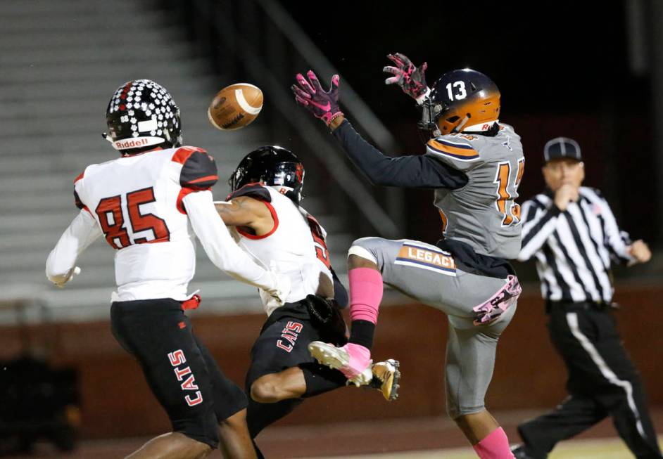 Legacy's Aaron Holloway (13) cannot catch a pass as Las Vegas' Jaelin Gray (85) and Devyn Perki ...