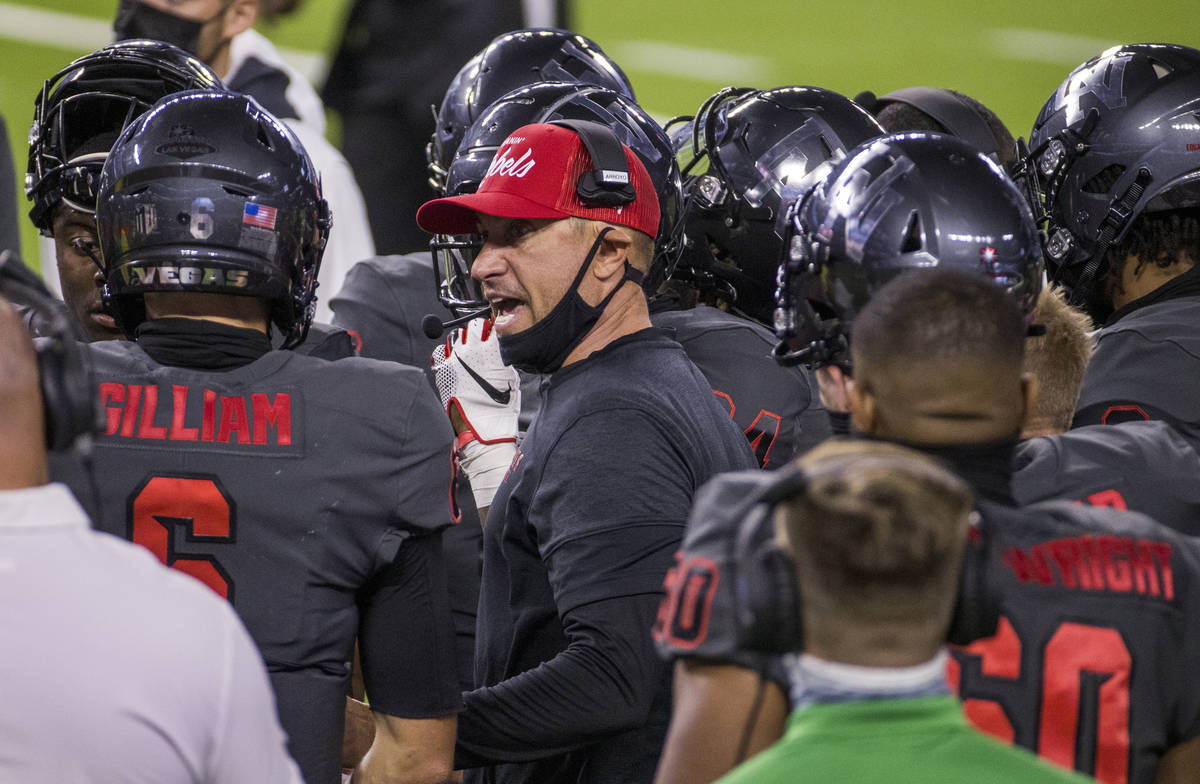 UNLV Rebels head coach Marcus Arroyo, center, speaks to quarterback Max Gilliam (6) and other ...