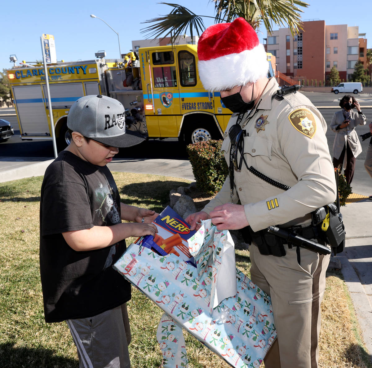 Las Vegas police officer Josh Irwin helps Kevin Salazar, 8, open gifts during the Metropolitan ...