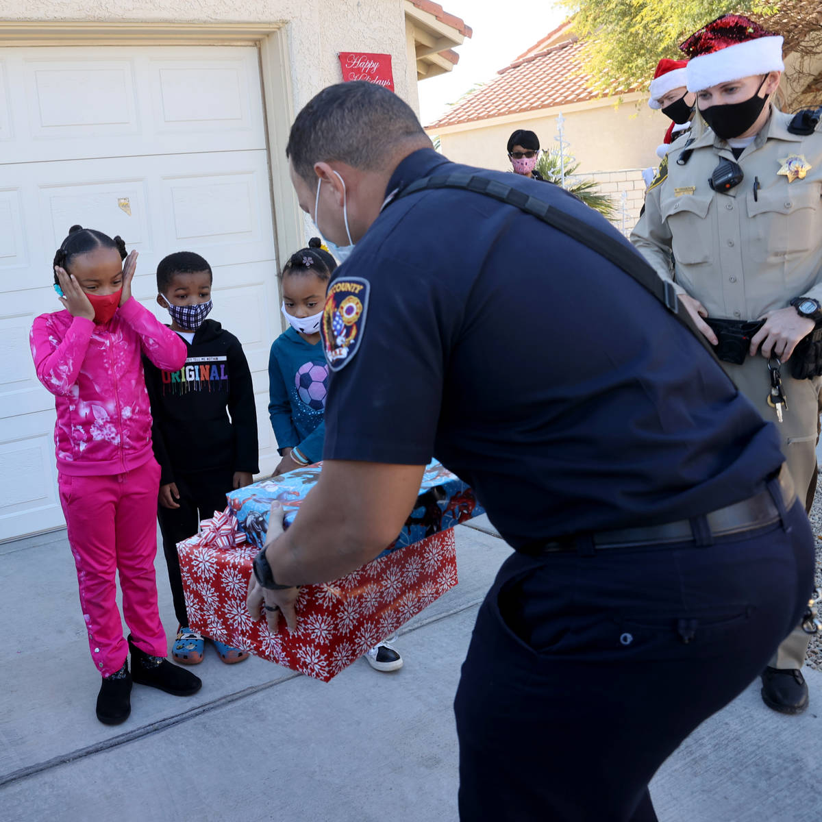 Clark County firefighter Calvin Dean and Las Vegas police officer Meike Dangervil deliver gifts ...