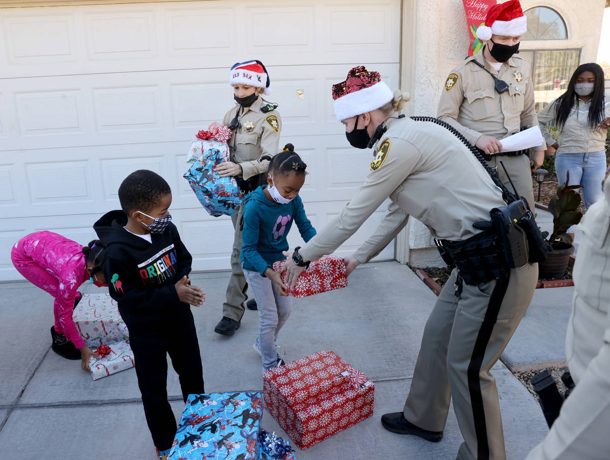 Las Vegas police officers, from left, A. Karas, Meike Dangervil and Mike Sian deliver gifts to ...