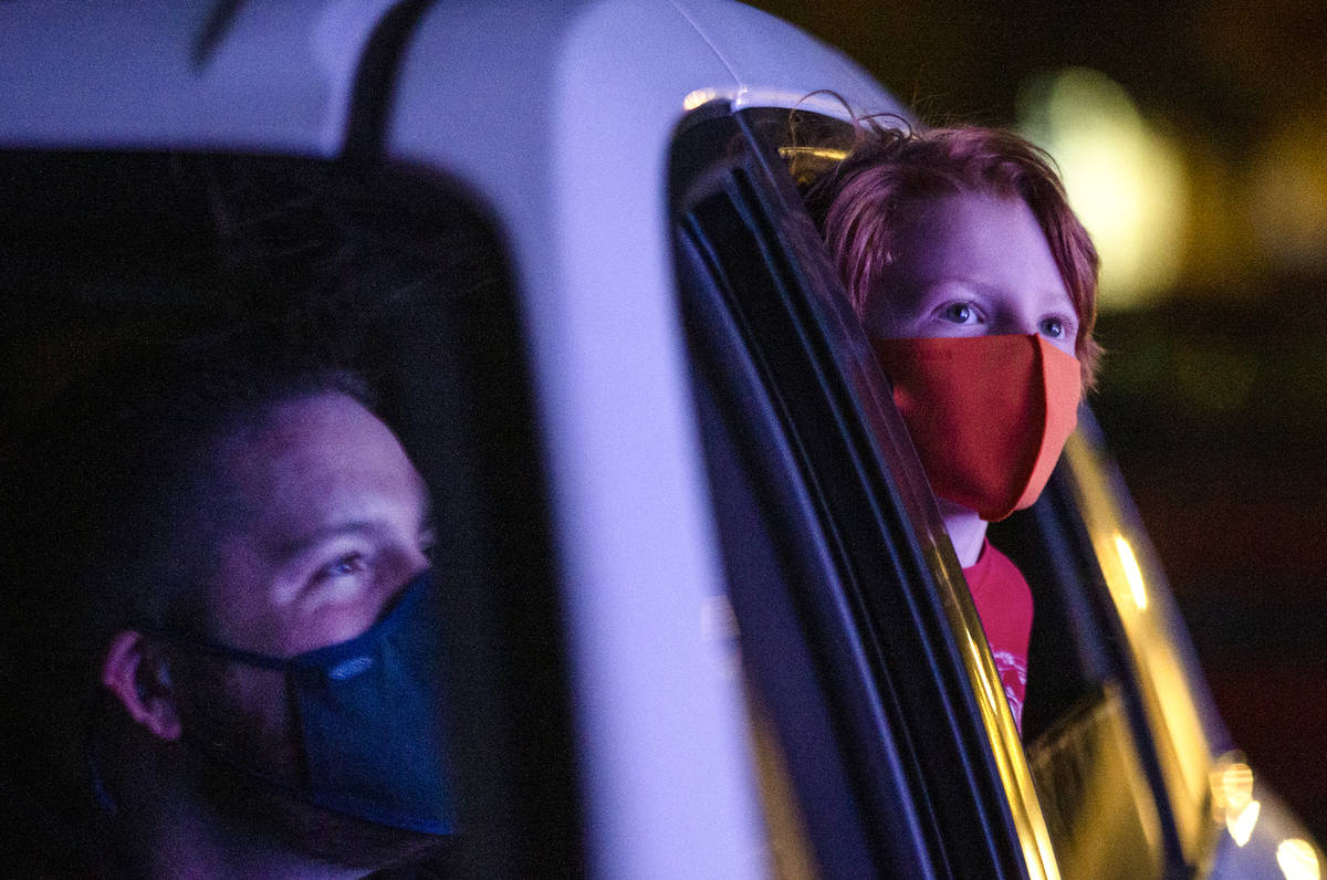 Joshua McCormack, left, and his 6-year-old son Benny McCormack, right, marvel at the lights on ...