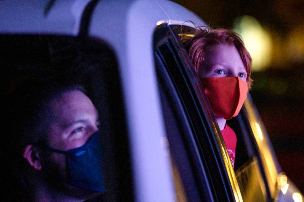 Joshua McCormack, left, and his 6-year-old son Benny McCormack, right, marvel at the lights on ...