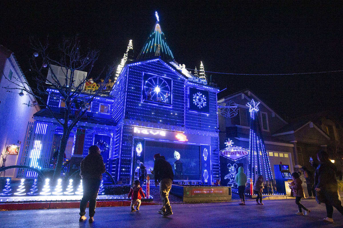 People stand outside to watch the Las Vegas Strip-themed light display at Jeff and Karol Doody' ...