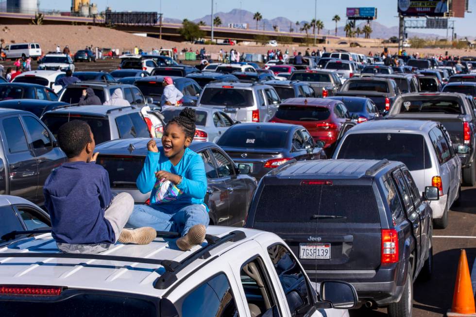 Isaih Brass, 9, and sister Unikiya Brass, 10, play atop their car as hundreds of drivers and pa ...