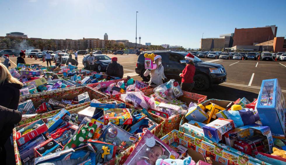 Volunteers greet drivers with toys as the Las Vegas Rescue Mission holds its toy drive on a fir ...