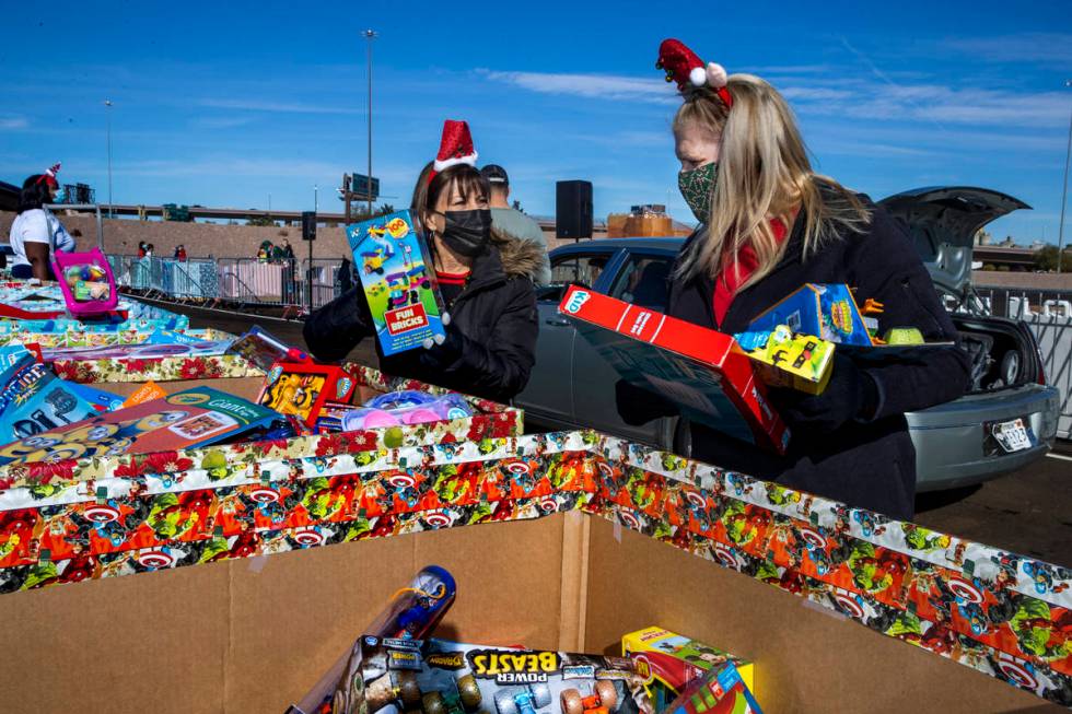 Gina Jones, left, and Patti Dillon grab more gifts to be distributed as the Las Vegas Rescue Mi ...