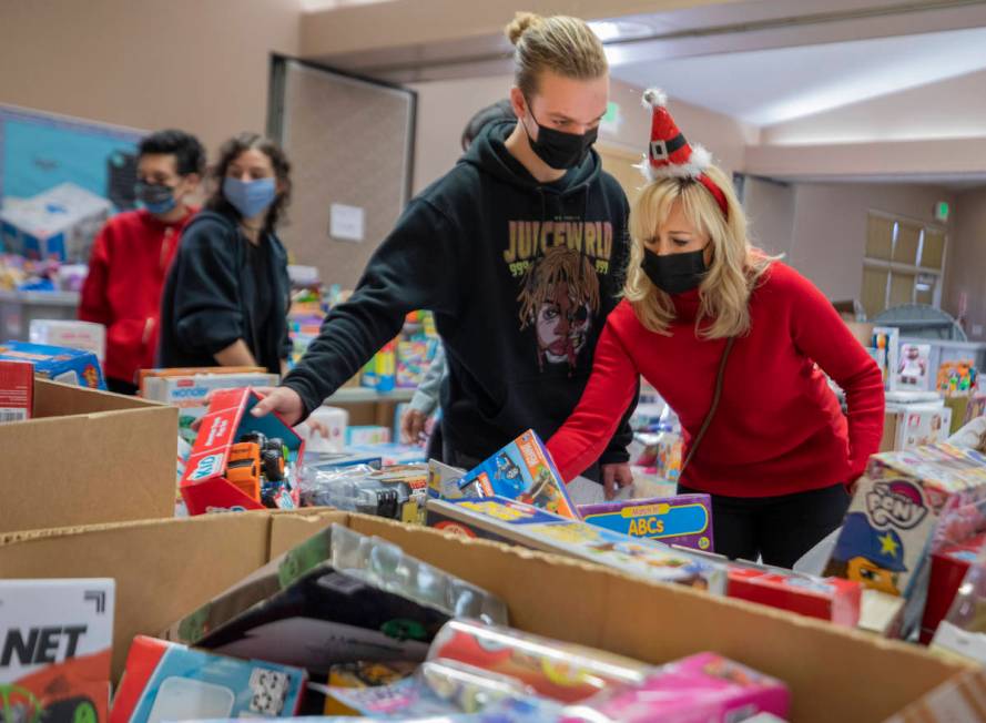 Volunteers Tanner Phillips, 17, left, and Jayme Phillips, 50, of Henderson pack Christmas donat ...