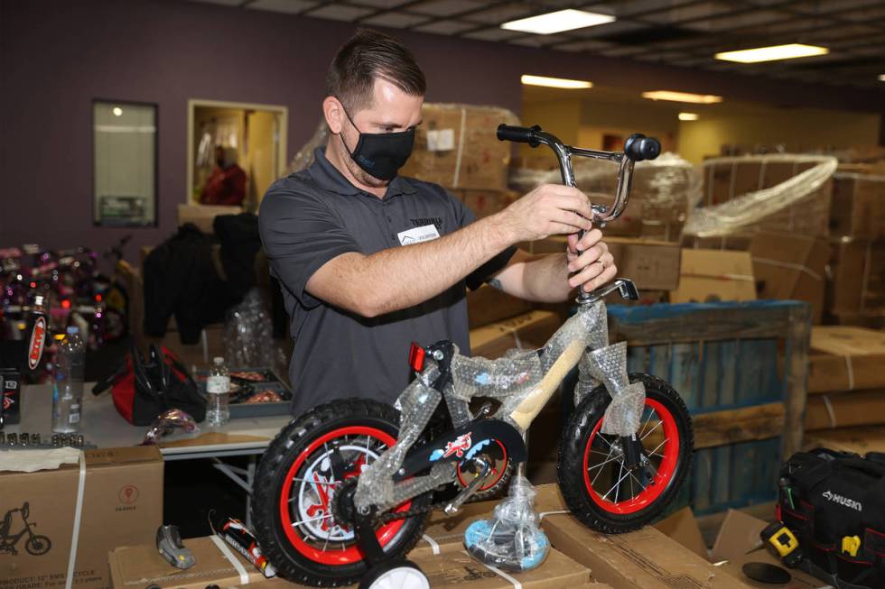 Volunteer Nick Voigt assembles a bicycle for the HELP of Southern Nevada toy drive distribution ...