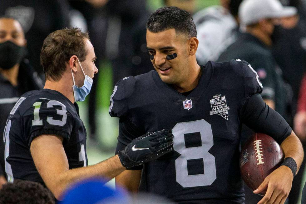 Raiders quarterback Marcus Mariota (8) speaks to Raiders wide receiver Hunter Renfrow (13) befo ...