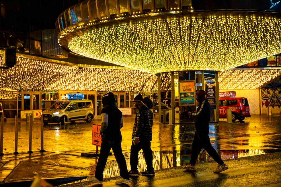 Pedestrians walk past a puddle in front of the Plaza in Downtown Las Vegas, Thursday, Dec. 17, ...