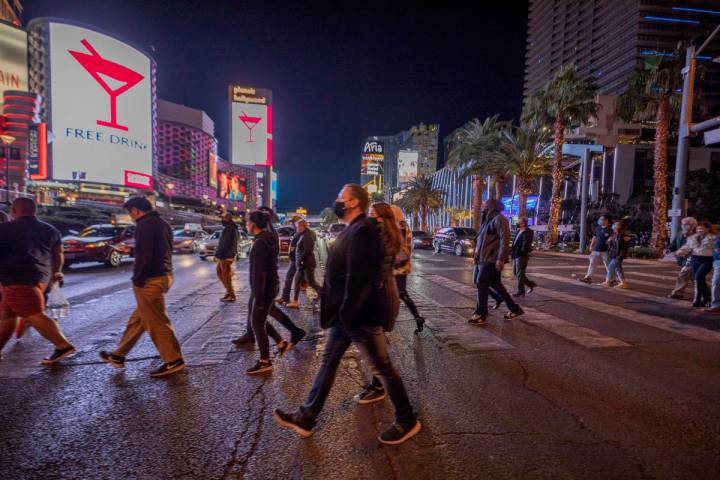 Tourists walk across Las Vegas Blvd., on the Strip, Friday, Nov. 27, 2020, in Las Vegas. (Eliza ...
