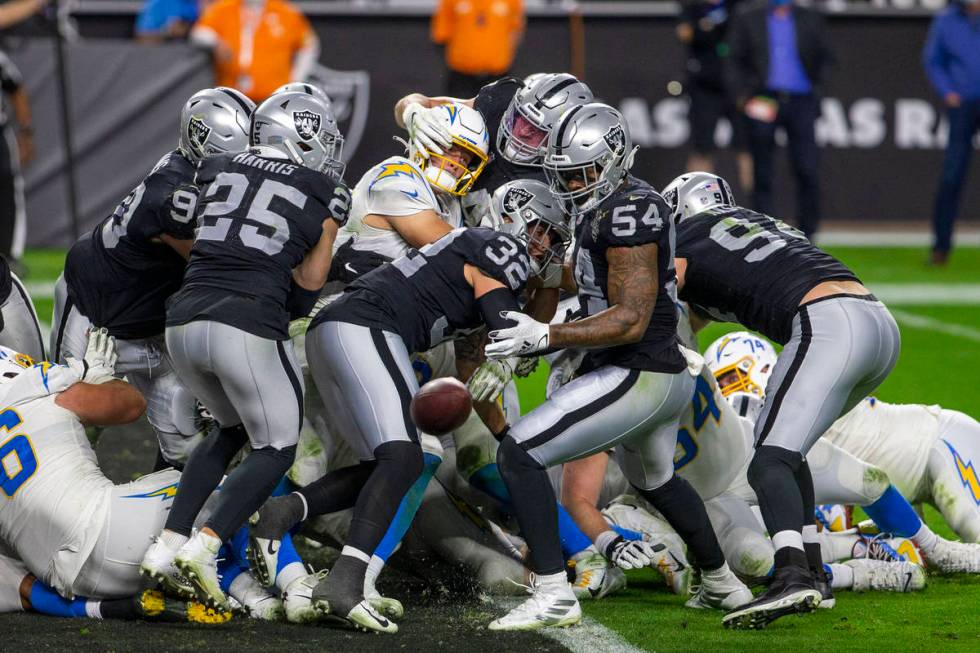 Los Angeles Chargers quarterback Justin Herbert (10) fumbles as he is hit by Raiders inside lin ...
