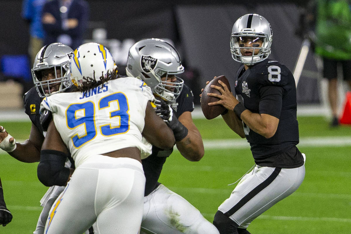 Raiders quarterback Marcus Mariota (8) drops back to pass as Los Angeles Chargers defensive tac ...