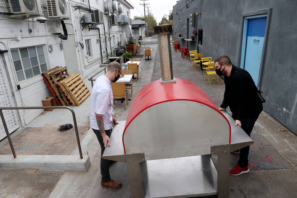 Alex White, left, and Cameron White of Yukon Pizza move their pizza oven at Vegas Test Kitchen ...