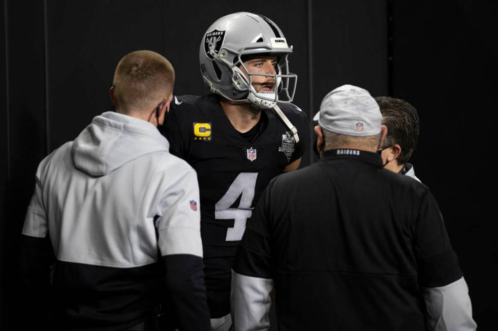 Raiders quarterback Derek Carr (4) is attended to by training staff after getting hurt scrambli ...