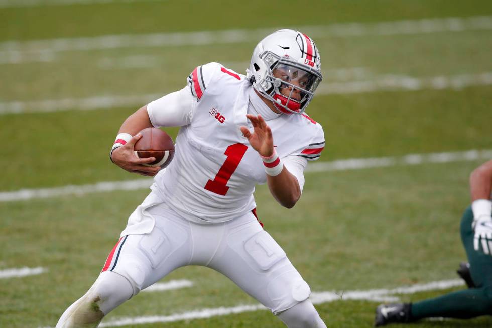 Ohio State quarterback Justin Fields scrambles against Michigan State during an NCAA college fo ...