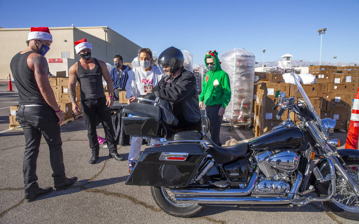 Chippendales' Ryan Kelsey, left, and Ryan Worley, center, with Jade Simone interact with motorc ...