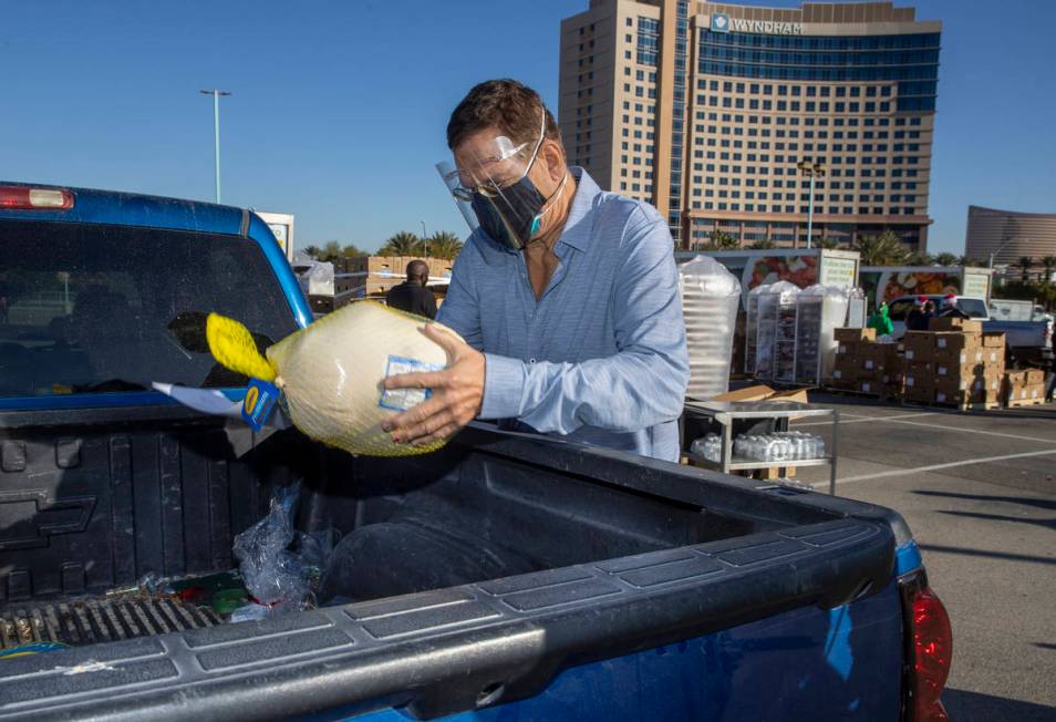 Penn Jillette delivers a turkey and cookies to an awaiting vehicle during the re-opening of the ...