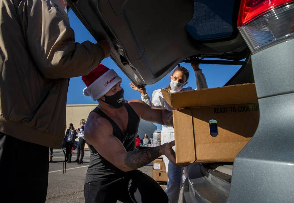 Chippendales member Ryan Worley loads up turkeys and cookies to an awaiting vehicle during the ...