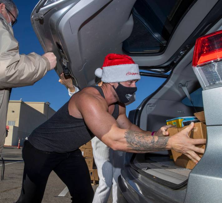 Chippendales member Ryan Worley loads up turkeys and cookies to an awaiting vehicle during the ...