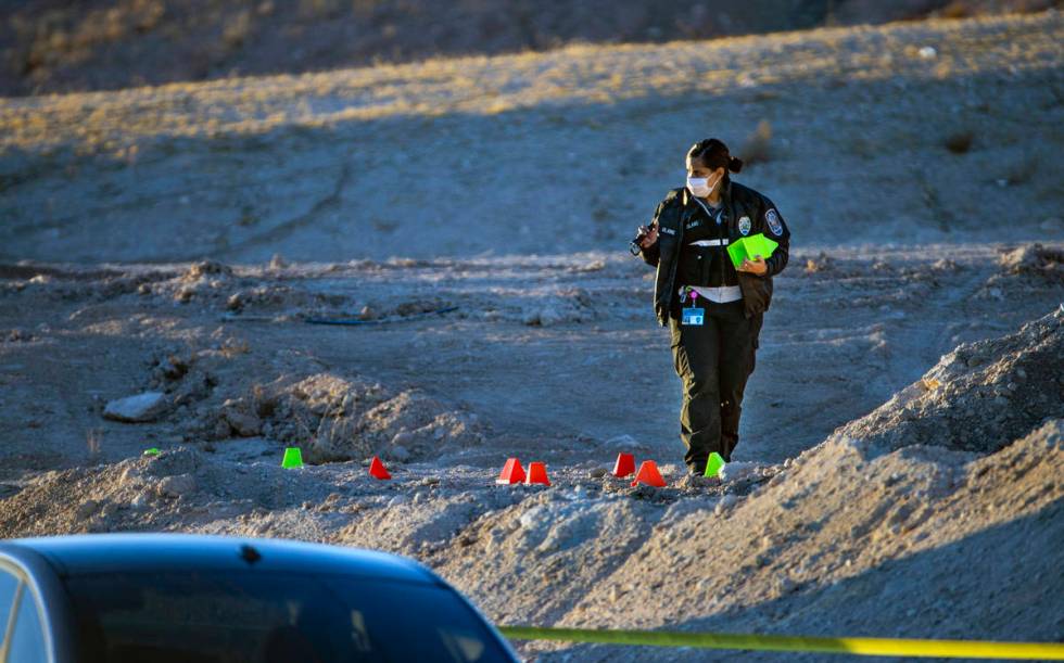 Lettered evidence markers are placed as North Las Vegas Police investigate a homicide along Wes ...