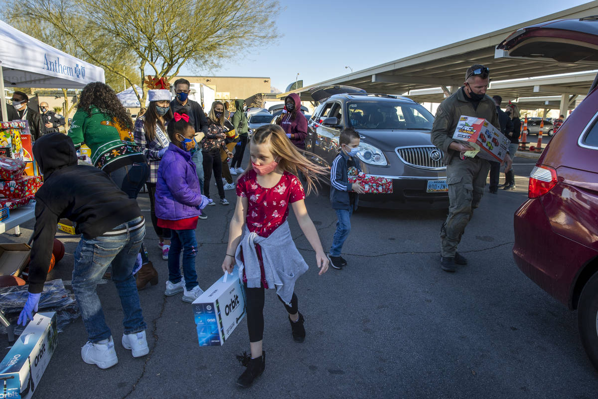 Madison Nelson, 7, center, carries a scooter as her brother Wyatt, 6, center right, works with ...