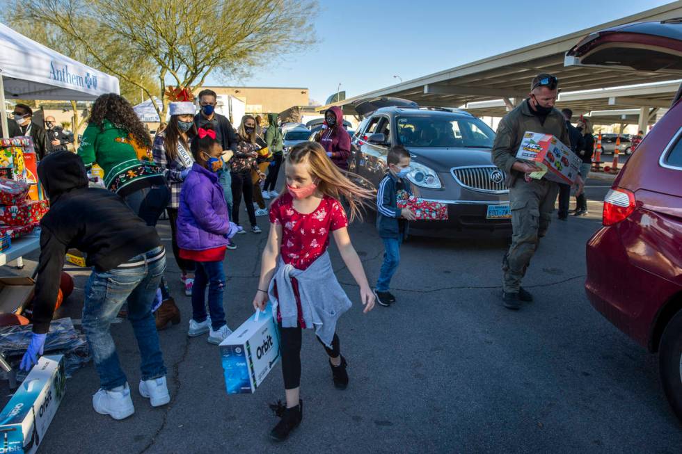 Madison Nelson, 7, center, carries a scooter as her brother Wyatt, 6, center right, works with ...