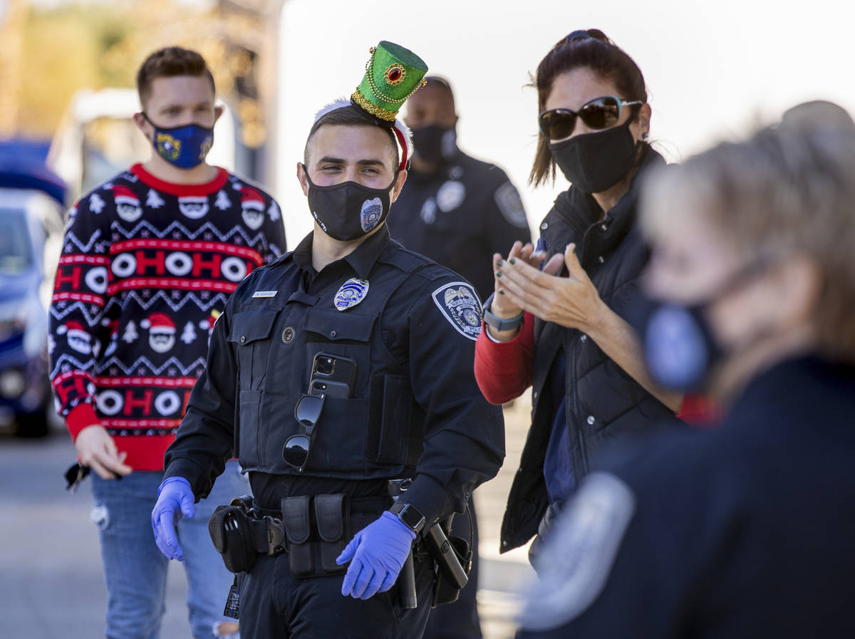 North Las Vegas Police Department P.I.O. Alexander Cuevas, center, joins other volunteers durin ...