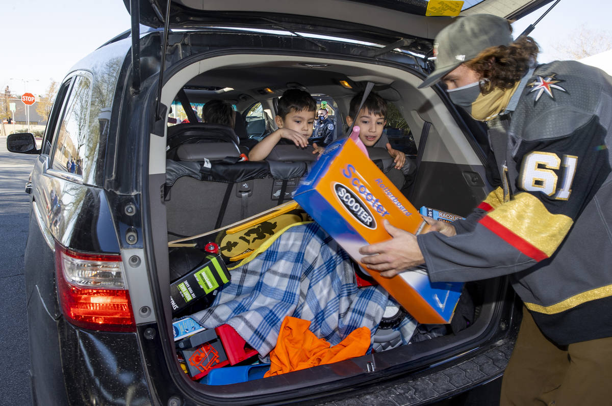 Golden Knights player Mark Stone loads up gifts during the first NLVPD Holiday Toy Giveaway dri ...