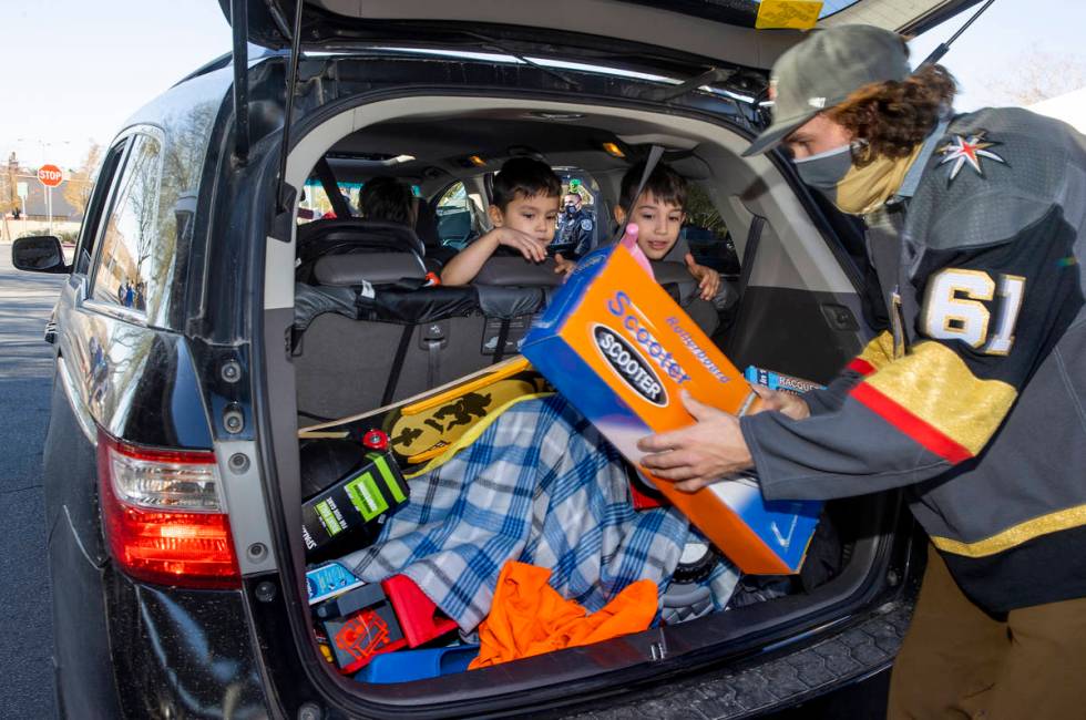 Golden Knights player Mark Stone loads up gifts during the first NLVPD Holiday Toy Giveaway dri ...