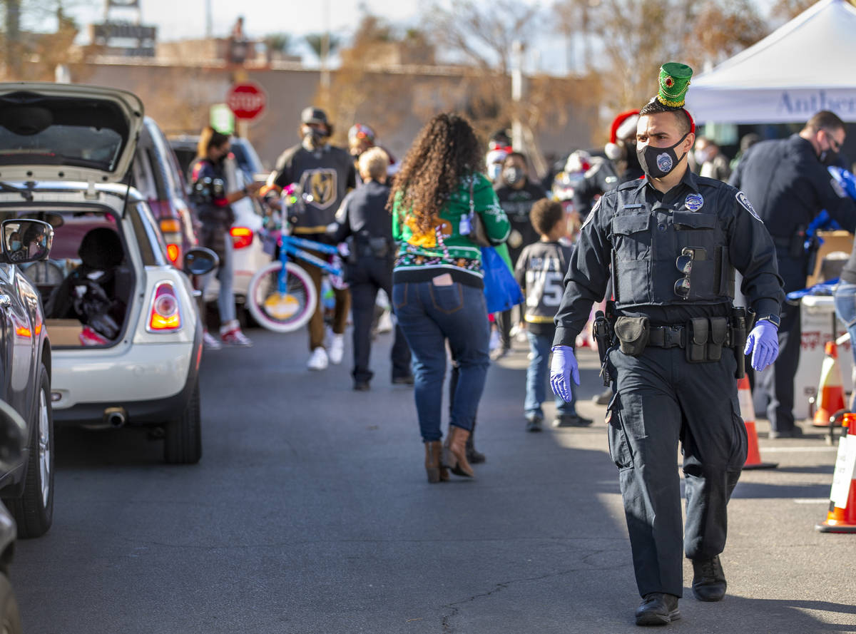 North Las Vegas Police Department P.I.O. Alexander Cuevas, center, joins other volunteers durin ...