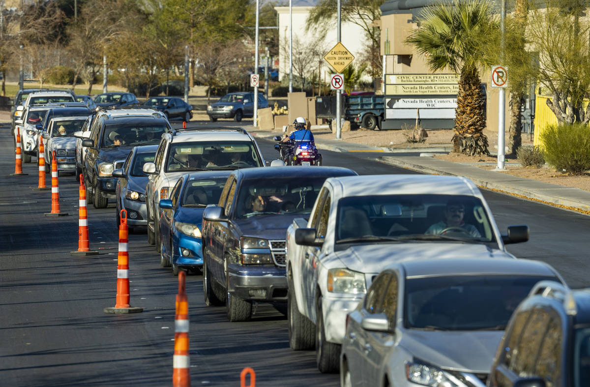 An officer begins to inform drivers that the line is closing during the first NLVPD Holiday Toy ...