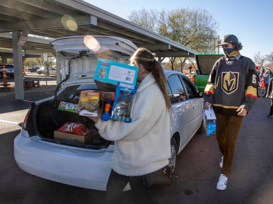 Golden Knights player Mark Stone, right, helps to load up gifts during the first NLVPD Holiday ...